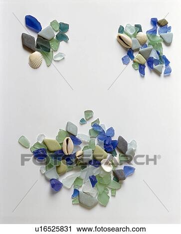 Stock Image - Close-up of small seashells with pieces of blue and green sea-glass. Fotosearch