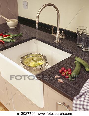 Close Up Of Stainless Steel Tap Pouring Water Into Colander In Belfast Sink Picture