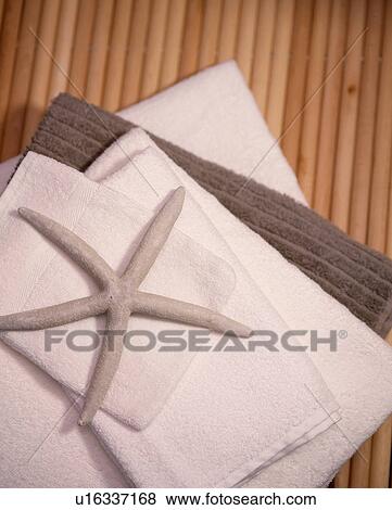 Stock Photo - Close-up of star-fish on pile of cream and brown towels. Fotosearch