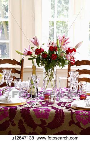 Close-up of table set for lunch with wine-glasses and glass vase of pink lilies on Designer's Guild cut-velvet cloth View Large Photo Image Stock Photo - Close-up of table set for lunch with wine-glasses and glass vase of pink lilies on Designer's Guild cut-velvet cloth. Fotosearch