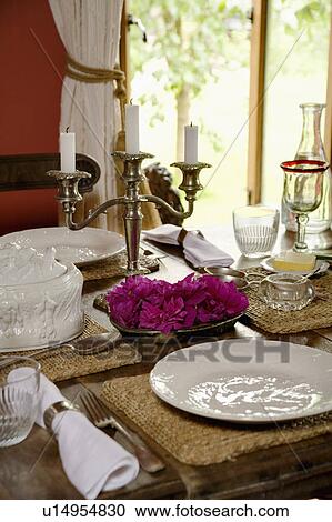 Stock Image - Close-up of table set with white plates and linen table napkins with candelabra. Fotosearch
