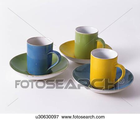 Stock Photo - Close-up of three multi-coloured cups and saucers. Fotosearch
