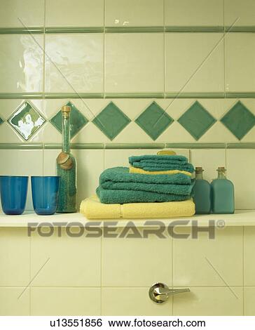Close-up of turquoise towels on shelf below white wall tiles with turquoise tiled border View Large Photo Image Stock Photograph - Close-up of turquoise towels on shelf below white wall tiles with turquoise tiled border. Fotosearch