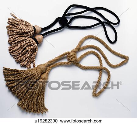 Stock Image - Close-up of two beige silk tasselled tie-backs. Fotosearch