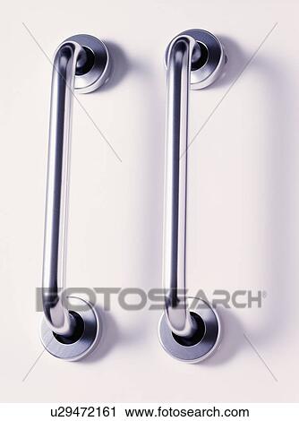 Stock Image - Close-up of two narrow metal door-handles. Fotosearch