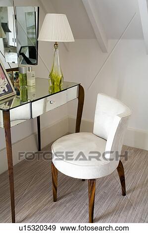 Close-up of upholstered white antique chair and antique mirrored dressing table View Large Photo Image Stock Photo - Close-up of upholstered white antique chair and antique mirrored dressing table. Fotosearch