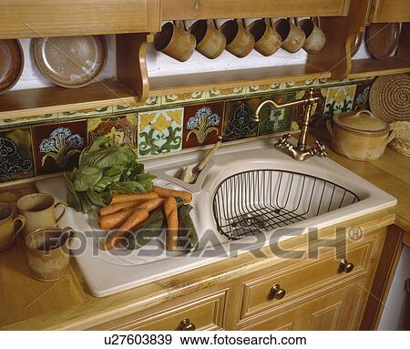 Close-up of vegetables on draining board of cream sink with draining basket View Large Photo Image Stock Photo - Close-up of vegetables on draining board of cream sink with draining basket. Fotosearch