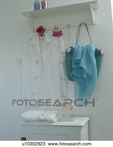 Close-up of white blouse and blue skarf on white pegboard View Large Photo Image Stock Image - Close-up of white blouse and blue skarf on white pegboard. Fotosearch