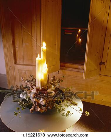 Close-up of white candle in moss and foliage Christmas decoration in front of shutters View Large Photo Image Stock Photo - Close-up of white candle in moss and foliage Christmas decoration in front of shutters. Fotosearch