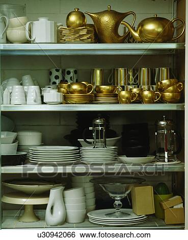 Close-up of white crockery with gilt teapots and vases on white shelves View Large Photo Image Stock Photograph - Close-up of white crockery with gilt teapots and vases on white shelves. Fotosearch