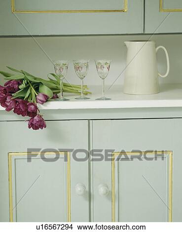 Picture - Close-up of white jug and wine-glasses on turquoise kitchen cupboard. Fotosearch