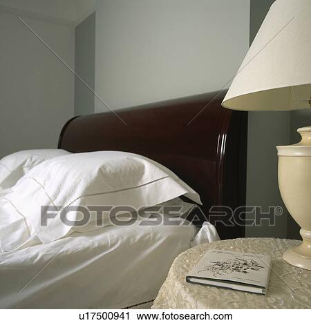 Close-up of white linen pillows and bedlinen on bed with polished wood headboard View Large Photo Image Stock Image - Close-up of white linen pillows and bedlinen on bed with polished wood headboard. Fotosearch