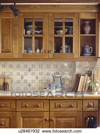 Close-up of white+blue wall-tiles and pale wood fitted units in small kitchen View Large Photo Image Stock Image - Close-up of white+blue wall-tiles and pale wood fitted units in small kitchen. Fotosearch