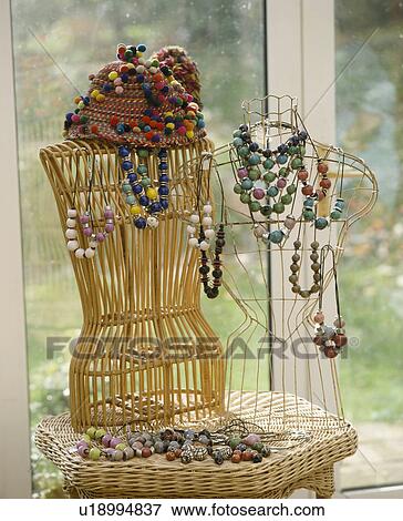 Close-up of wicker and wirework tailor's dummies draped with bead necklaces on small wicker table View Large Photo Image Stock Photo - Close-up of wicker and wirework tailor's dummies draped with bead necklaces on small wicker table. Fotosearch