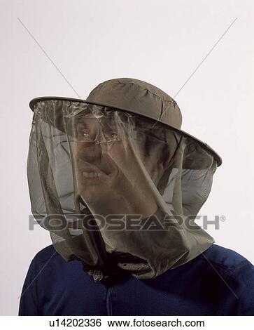 Stock Photograph - Close-up of woman wearing bee-keeper's protective headgear. Fotosearch
