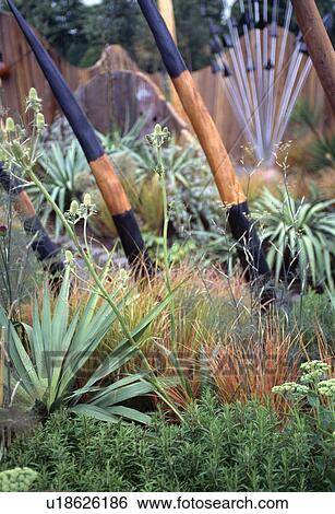 Close up of wooden pole sculpture with grasses and spiky iris leaves View Large Photo Image Stock Photograph - Close up of wooden pole sculpture with grasses and spiky iris leaves. Fotosearch