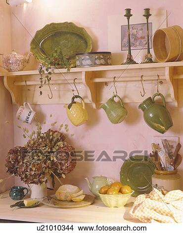 Close-up of yellow and green jugs hanging from hooks on wooden shelf View Large Photo Image Picture - Close-up of yellow and green jugs hanging from hooks on wooden shelf. Fotosearch