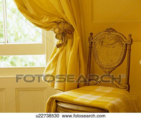 Close-up of yellow Fortuny silk curtain on window and chair with yellow checked rug View Large Photo Image Stock Image - Close-up of yellow Fortuny silk curtain on window and chair with yellow checked rug. Fotosearch
