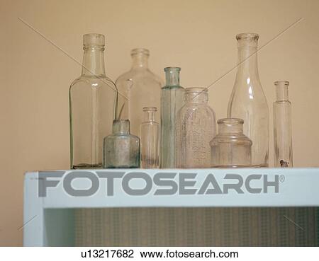 Collection of old glass bottles on turquoise shelf View Large Photo Image Stock Image - Collection of old glass bottles on turquoise shelf. Fotosearch