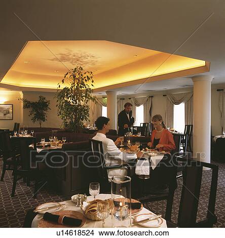 Picture - Couple dining in traditional restaurant with ceiling lighting. Fotosearch