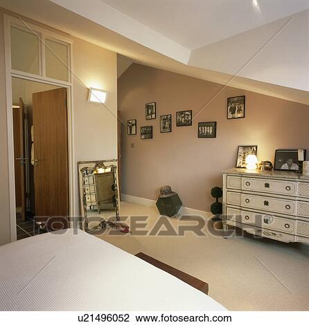 Stock Image - Cream carpet in beige townhouse bedroom with cream chest-of-drawers. Fotosearch