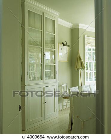 Picture - Cream dresser with glazed doors in pale grey country dining room. Fotosearch