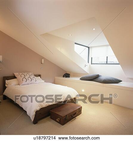 Cream duvet on bed in modern attic bedroom with cream carpet fitted storage below dormer window View Large Photo Image Picture - Cream duvet on bed in modern attic bedroom with cream carpet fitted storage below dormer window. Fotosearch
