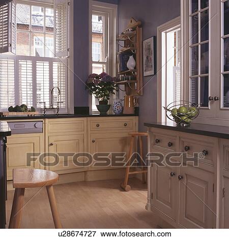 Cream fitted units in turquoise townhouse kitchen View Large Photo Image Stock Photo - Cream fitted units in turquoise townhouse kitchen. Fotosearch