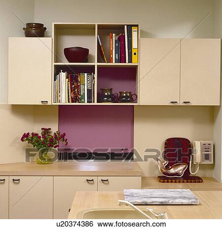 Cube shelving between cream fitted cupboards in small kitchen with dark pink hatch View Large Photo Image Stock Photograph - Cube shelving between cream fitted cupboards in small kitchen with dark pink hatch. Fotosearch