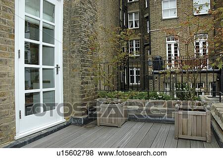 Decked balcony garden with glazed white door to house View Large Photo Image Stock Photo - Decked balcony garden with glazed white door to house. Fotosearch