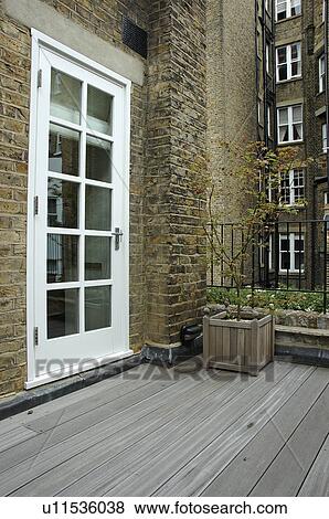 Decked balcony with glazed white door to house View Large Photo Image Stock Photo - Decked balcony with glazed white door to house. Fotosearch