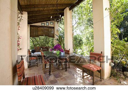 Dining table and chairs on veranda of house in Mallorca View Large Photo Image Stock Photo - Dining table and chairs on veranda of house in Mallorca. Fotosearch