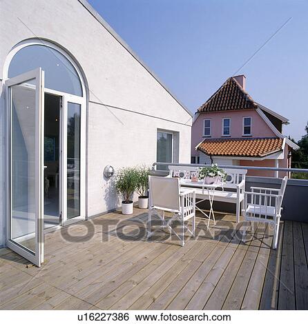 Director's chairs and white bench on large decked balcony of house with glass patio doors View Large Photo Image Stock Photograph - Director's chairs and white bench on large decked balcony of house with glass patio doors. Fotosearch