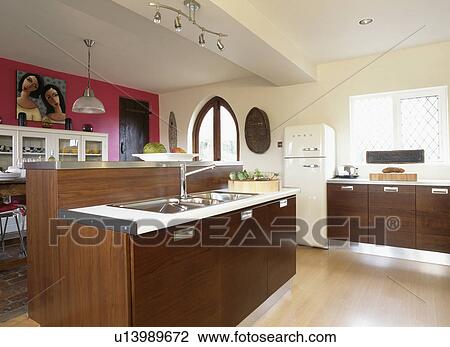 Stock Image - Double sinks in brown island unit in modern kitchen. Fotosearch
