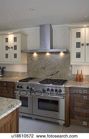 Stock Image - Dual fuel range oven with granite splash back in modern kitchen. Fotosearch