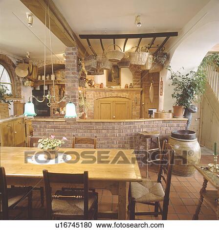 Edwardian pendant lighting above pine table in dining area of large country kitchen View Large Photo Image Stock Image - Edwardian pendant lighting above pine table in dining area of large country kitchen. Fotosearch