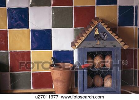 Eggs in small wooden cupboard in front of colourful wall tiles View Large Photo Image Stock Photo - Eggs in small wooden cupboard in front of colourful wall tiles. Fotosearch