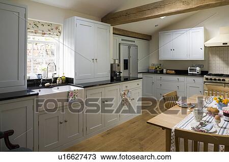 Engineered oak flooring in large country kitchen with white fitted units and cupboards View Large Photo Image Stock Image - Engineered oak flooring in large country kitchen with white fitted units and cupboards. Fotosearch