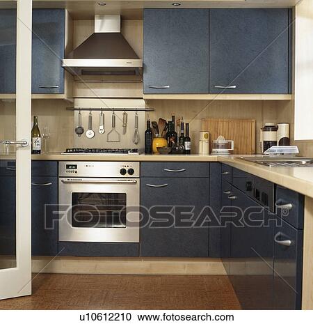 Extractor above oven and grey-blue fitted units in modern townhouse kitchen View Large Photo Image Stock Image - Extractor above oven and grey-blue fitted units in modern townhouse kitchen. Fotosearch