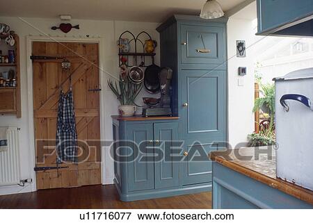 Stock Photo - Fitted blue units in traditional country kitchen. Fotosearch