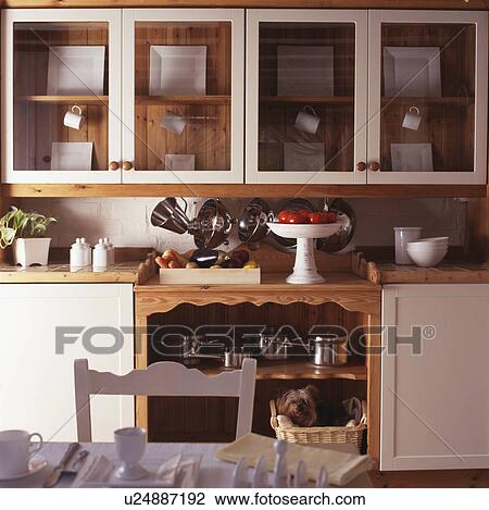 Fitted cupboards with glazed doors above cream units in cream cottage kitchen View Large Photo Image Stock Image - Fitted cupboards with glazed doors above cream units in cream cottage kitchen. Fotosearch