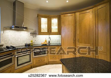 Fitted oak storage cupboards and tumbled marble mosaic wall tiles in oast house kitchen View Large Photo Image Stock Photo - Fitted oak storage cupboards and tumbled marble mosaic wall tiles in oast house kitchen. Fotosearch