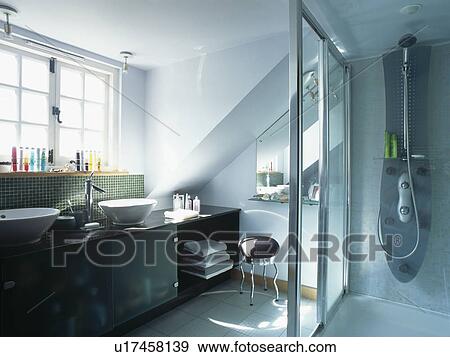 Fitted vanity unit and glass shower door in modern attic bathroom View Large Photo Image Stock Photo - Fitted vanity unit and glass shower door in modern attic bathroom. Fotosearch