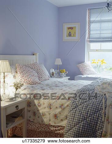 Stock Photo - Floral bedlinen on bed in blue country bedroom. Fotosearch
