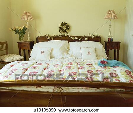 Floral quilt and white bedlinen on mahogany bed in cream country bedroom View Large Photo Image Stock Image - Floral quilt and white bedlinen on mahogany bed in cream country bedroom. Fotosearch