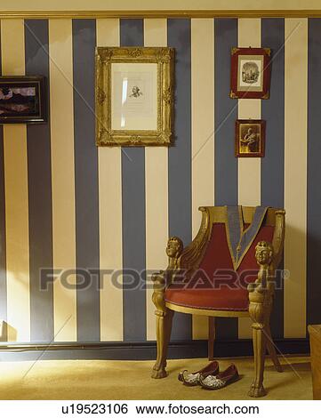Stock Photograph - Gilt chair and wall with hand-painted blue+white stripes. Fotosearch