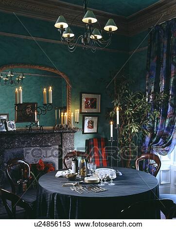 Gilt mirror above lighted candles on mantelpiece in green dining room with red tartan throw on chair View Large Photo Image Stock Image - Gilt mirror above lighted candles on mantelpiece in green dining room with red tartan throw on chair. Fotosearch
