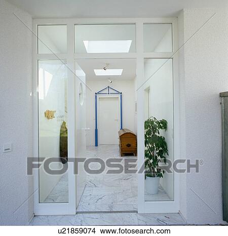 Picture - Glass doors to modern white hall with marble flooring. Fotosearch