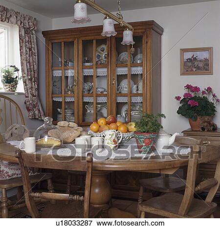 Glass-fronted cupboard in small cottage dining room View Large Photo Image Stock Photo - Glass-fronted cupboard in small cottage dining room. Fotosearch