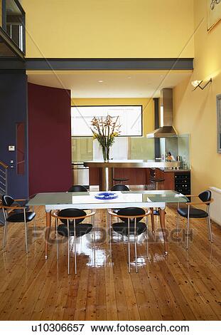 Glass table and black chairs in openplan kitchen dining room with wooden flooring View Large Photo Image Stock Photo - Glass table and black chairs in openplan kitchen dining room with wooden flooring. Fotosearch